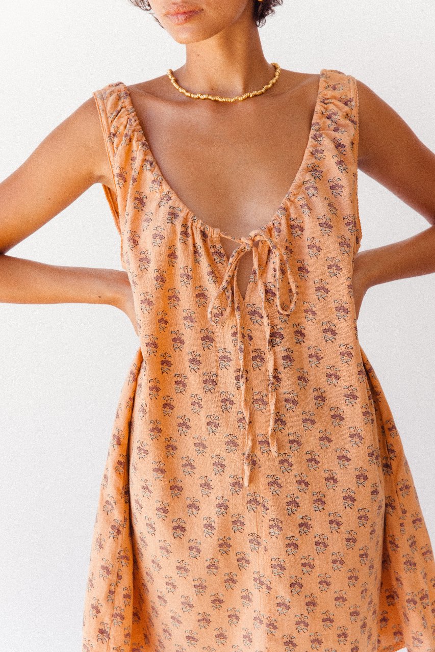 Sundress Mini Peach — ghost flat lay product shot, dress displayed flat showing full shape, peach floral hand block print cotton mini sundress, sleeveless | Daughters of India artisan Jaipur