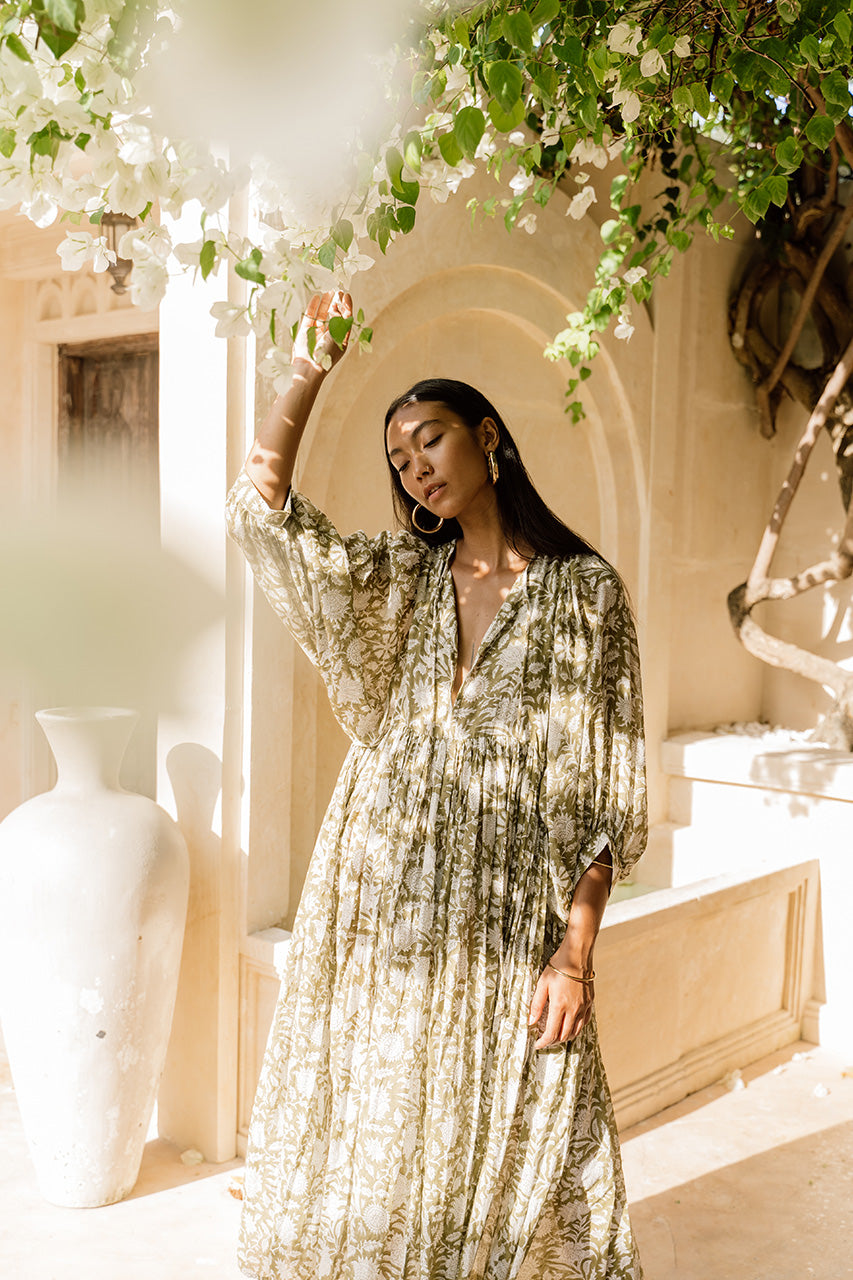 Daughters of India Kyra Midi Dress in Olive — full length under bougainvillea by arched wall, flowing hand screen print