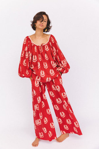 Ria Pants Ruby Red — studio side view detail, model wearing ruby red hand block print cotton wide-leg pants showing flowing silhouette, botanical leaf motif, artisan Jaipur India | Daughters of India