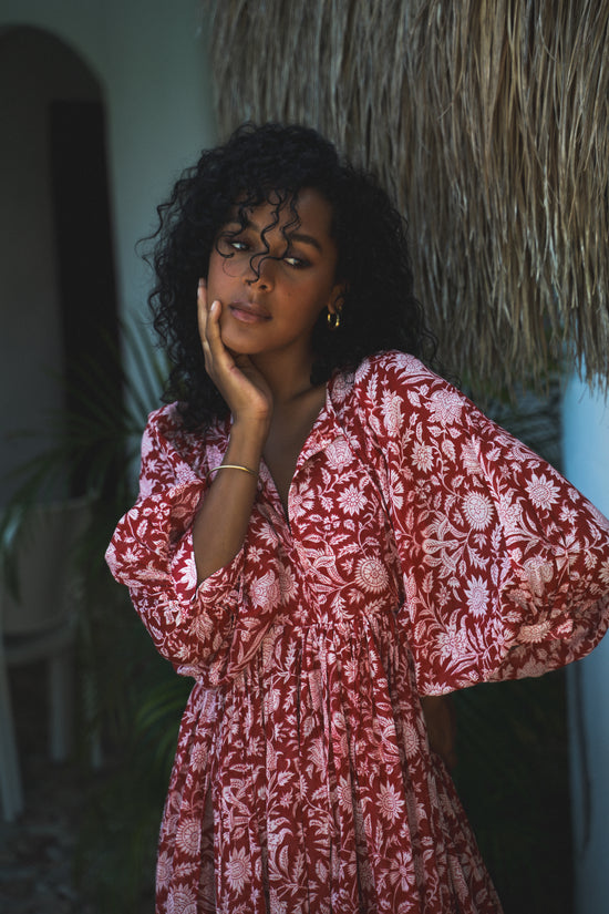 Daughters of India Kyra Midi Dress in Saffron — seated at thatched hut, white floral print cotton